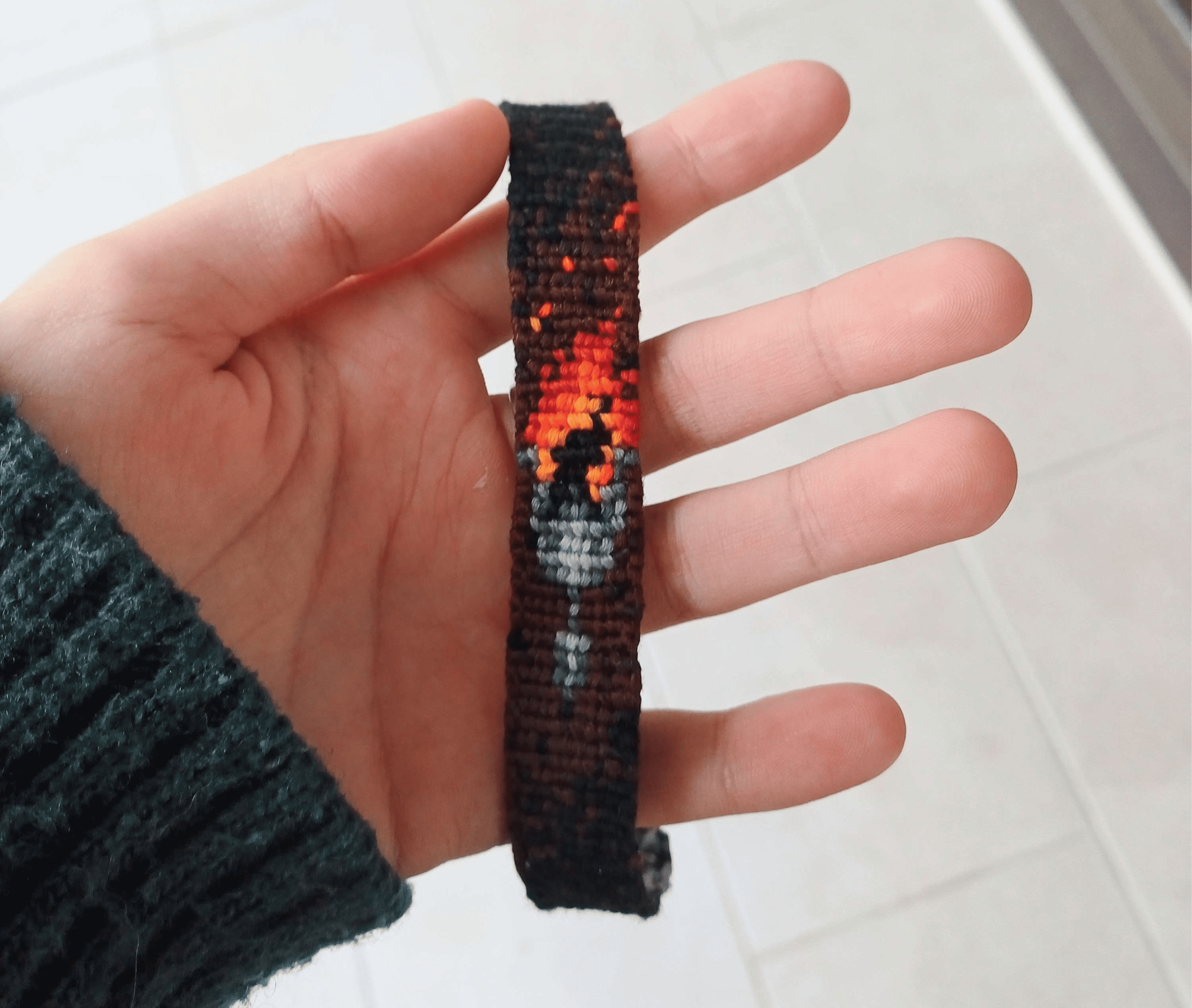weaved bracelet with a drawing of a torch in it